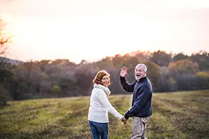 Seniors Prints: Senior couple walking in an autumn nature, holding hands