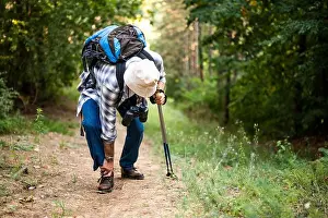 Ankle Prints: Senior hiker is struggling with ankle injury while standing in forest during hiking