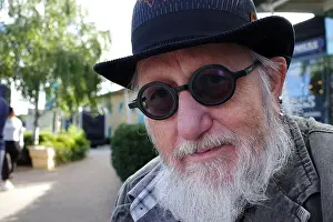 Defocused Prints: Senior man with a beard wears round black glasses and a bowler hat
