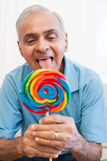 Licking Prints: Senior man licking a lollipop