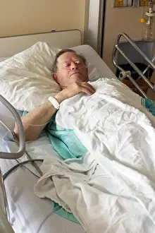 Senior man lying in hospital bed getting oxygen in intensive care unit, vertical