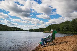 Fishing Rod Prints: Senior man sitting by the river fishing