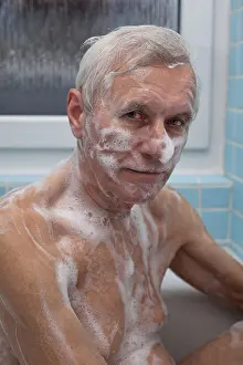 Froth Prints: Senior man washing his body with soap in bath