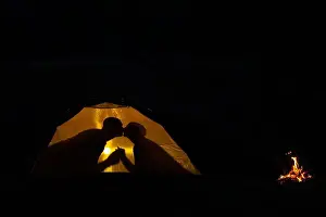 Honeymoon Prints: Shadow of a couple in love kisses in a tourist tent in nature. camping in the wilderness