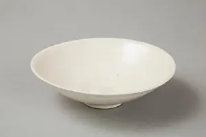 Smith Prints: A shallow cream glazed bowl with rolled rim andraised footrim