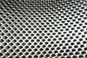 Toughness Prints: shiny metal surface with perforation. Fragment of the washing machine drum