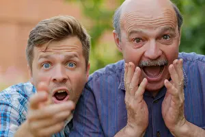 Lottery Prints: Two shocked men father and son looking at camera with opened mouth