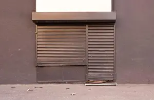 Blinds Prints: Empty shop with closed blinds on urban city street ready for renting
