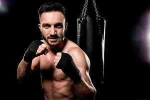 Boxer Prints: shortless sportsman looking at camera and standing in boxing pose on black background