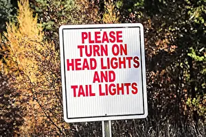 Advise Prints: A sign indicating to turn on all vehicle lights