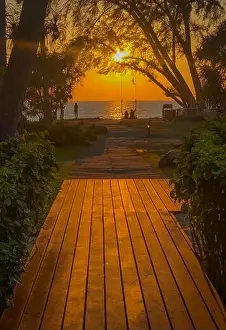 Couple Relationship Prints: Silhouette of a couple on a swing enjoying a glorious golden sunset at the beach