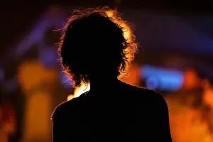 Unrecognizable Prints: silhouette of an unrecognizable person sitting in the front of the fire