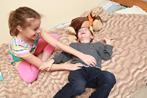 Sister tickling her younger brother