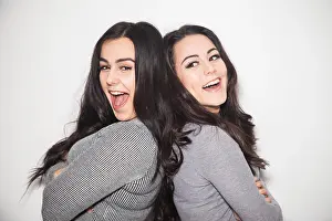 Sisters Prints: Two sisters leaning back to back laughing