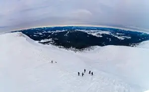 Skiers Prints: Skiers on top. Amazing aerial view of a hill covered with a thick layer of snow on a cloudy foggy day