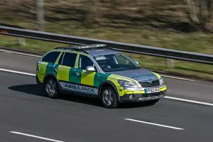 Urgency Prints: Skoda Octavia private ambulance driving on the M6 motorway near Preston in Lancashire, UK