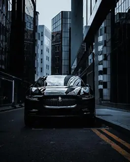 Gleaming Prints: A sleek black sports car is parked on the street of a bustling city