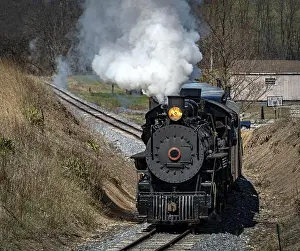 Load Prints: A Front and Slightly Above View of an Approaching Restored Narrow Gauge Passenger Steam Train Blowing Smoke