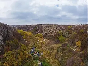 A small fast stream Kamenka in the wilderness in the evening light in Ukraine. Aerial panoramic drone shot
