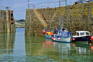 Reflections Prints: Small fishing boats moored against the harbour wall in the picturesque fishing village of Mousehole on the south
