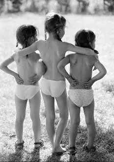 Sisters Prints: Three small girls standing outside in underwear, rear view, b&w