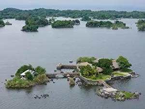 Small tropical island with helipad and pool aerial drone view