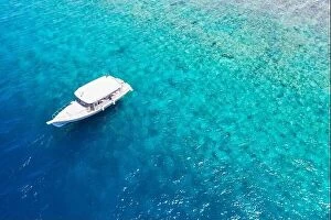 Images Dated 3rd June 2019: Small yacht sailing in tropical sea over coral reef in Indian ocean lagoon