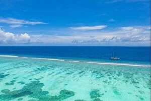 Images Dated 3rd June 2019: Small yacht sailing in tropical sea over coral reef in Indian ocean lagoon