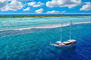 Small yacht sailing tropical sea over coral reef in Indian ocean lagoon. Exotic island landscape aerial view, stunning nature scenic freedom adventure