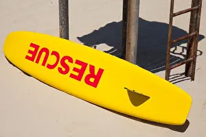 Lifeguard Prints: Small yellow rescue boat lays on the beach