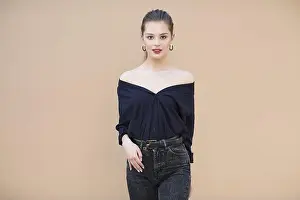Long Haired Prints: Smiling fashion model wearing navy blue blouse on beige background