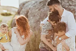 Weekend Activities Prints: Smiling father embracing sons while mother looking at baby girl against rock formation