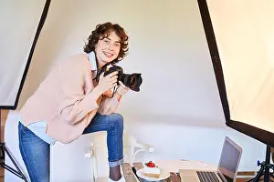 Apprenticeship Prints: Smiling food photographer with camera and piece of pie in the photo studio