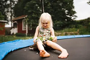 Bangs Prints: Smiling girl sitting on trampoline