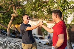 Summer Day Prints: Two smiling men greet each other with a handshake outdoors, radiating friendship