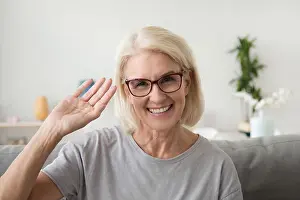Vlogger Prints: Smiling middle aged woman waving hand looking at camera, portrai