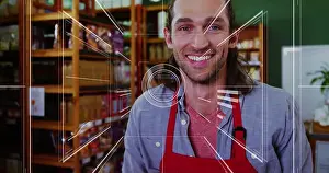 Inventory Prints: Smiling shop employee wearing red apron stocking wooden shelves in shop