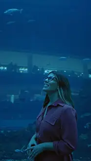 Marinebiology Prints: A smiling woman enjoys the view at an underwater aquarium in dubai