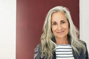 Beautiful Woman Prints: Smiling woman with gray hair against maroon background
