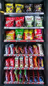 Tempting Prints: Snack vending machine / snack dispenser selling colourful sweets and chocolate bars in public place