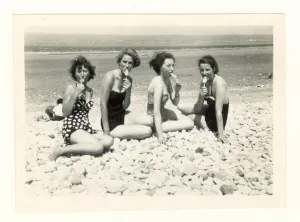 Looking At The Camera Prints: Snapshot of four attractive young women wearing fashionable swimsuits with iced lollies on the beach at Rhyl