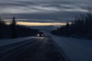 Delta Junction Prints: Snow blowing around truck driving on Richardson Highway on a dark winter morning in interior Alaska between Tok