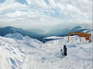 Shovel Prints: Snow-covered ski hoist ropeway (upper terminal) and mountain landscape behind (Ukraine)