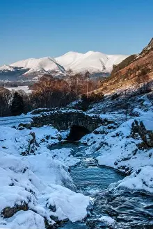 Flowing Water Prints: A snow covered winter scene at Ashness Bridge with Skiddaw mountain in the background