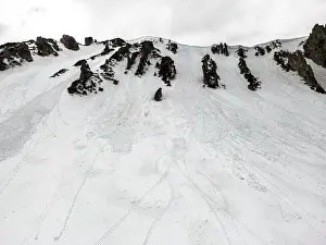 Infused Prints: A snowy mountain Shpyci with ski tracks on it and a cloudy sky in the background