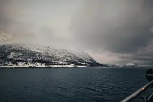 Brim Prints: Snowy mountains under clouds by the arctic ocean in northern Norway