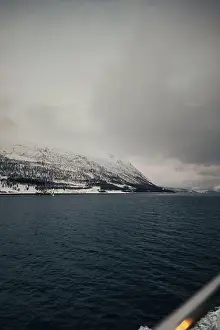 Brim Prints: Snowy mountains under clouds by the arctic ocean in northern Norway in winter