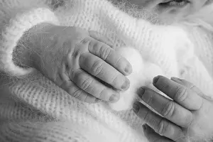 Toes Prints: Soft hands of new born hold woolen heart. Fingers of newborn baby hands close up
