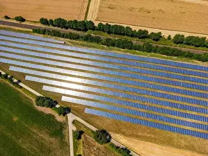 Solar Farm Prints: A solar park with many rows of solar collectors and solar panels in a rural area with agriculture