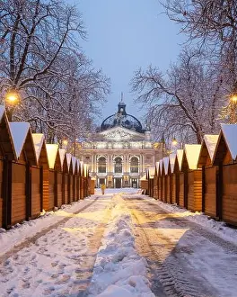 Solomiya Krushelnytska Lviv State Academic Theatre of Opera and Ballet in winter time. Wooden Christmas fair kiosk in a row with city light in